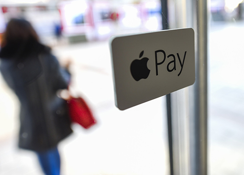 在北京王府井商业区的一家商户玻璃门上，粘贴有Apple Pay标识（2月18日摄）。2月18日，苹果公司携手中国银联和19家中国商业银行，正式向中国大陆市场推出移动支付服务“苹果支付”（Apple Pay）。