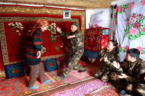 2月19日，在热合木·别尔地家中，边防派出所民警和热合木·别尔地的妻子（左一）跳起了哈萨克传统舞蹈“黑走马”。当日，武警新疆伊犁边防支队开干沟边防派出所的民警们提着花灯、带着元宵，来到位于中国——哈萨克斯坦边境的霍城县阿拉马力胡勒加拜沟，看望这里的哈萨克族护边员热合木·别尔地一家，迎接即将到来的元宵节。新华社发（贾航超 摄）