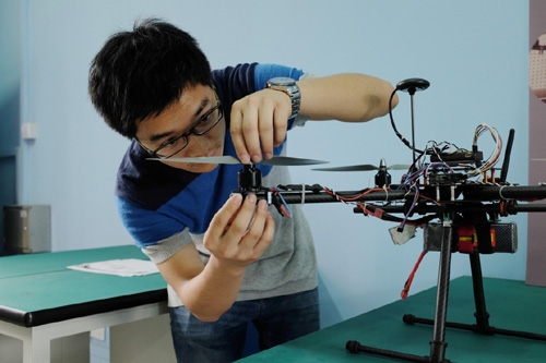 在东华大学众创空间，机械工程专业学生周有为在调试无人机（2015年5月14日摄）。东华大学众创空间是上海首个高校众创空间。一期建设以东华大学工程训练中心、实验室等为载体，为学生提供3D打印机、数控机床、智能切割机等实体工具及各种网络资源，帮助大学生将奇思妙想转化为现实产品，为有志于创新创业的大学生提供交互平台。