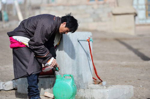 2月22日，甘肃省甘南藏族自治州夏河县桑科乡牧民才让道吉在自家的冬季牧场居住点接自来水。