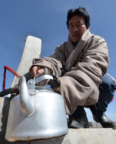 2月22日，甘肃省甘南藏族自治州夏河县桑科乡冬季牧场居住点的一位牧民在接自来水。