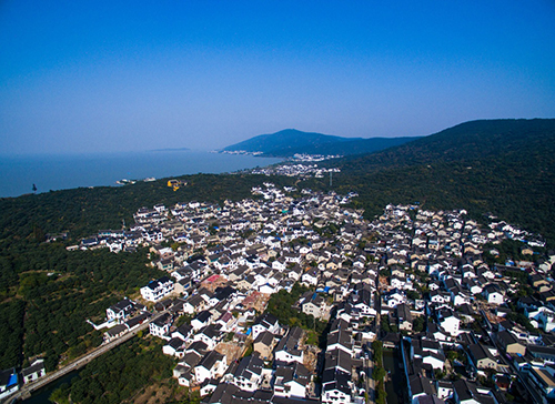 太湖畔的江苏省苏州市吴中区东山镇陆巷古村景色（资料照片）。太湖位于苏浙两省交界处，在长三角地区具有重要的经济和生态地位。上世纪90年代，太湖生态破坏严重，水质恶化；2007年太湖蓝藻暴发，引发供水危机，更给太湖流域的环境保护敲响了警钟。近年来，环太湖各城市投入巨大努力，关停污染企业，实行底泥疏浚、湿地修复与保护、河网综合整治、环湖林地修复等工程，太湖水质日益改善，综合生态环境得到恢复。同时，环太湖各地积极引导居民发展绿色种养殖业和生态观光旅游业等，一条绿色农业、生态观光、休闲旅游的环湖产业带初现雏形。在发展同时注重环保，优良环境又成为发展优势，环境和富民实现“双赢”，生动印证了“绿水青山就是金山银山”。