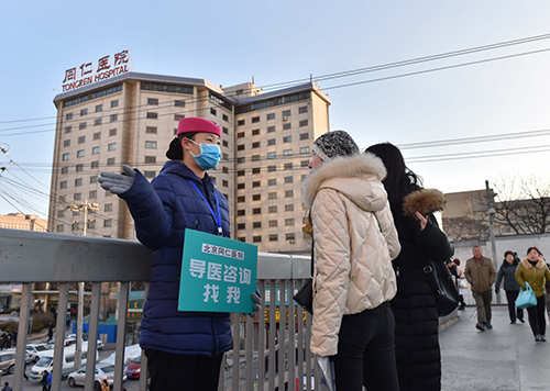 2月26日，北京同仁医院的工作人员走出医院，引导市民就诊，并解答他们的问题。