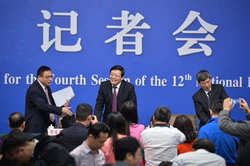 3月7日，十二届全国人大四次会议新闻中心举行记者会，邀请财政部部长楼继伟、部长助理许宏才就“财政工作和财税改革”的相关问题回答中外记者的提问。这是记者会结束后，记者上前继续向楼继伟提问。