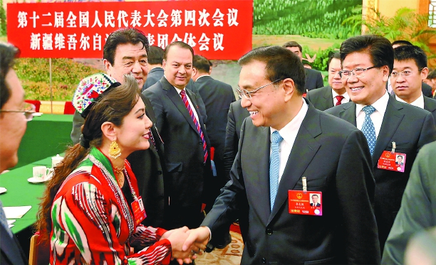 3月10日上午，中共中央政治局常委、国务院总理李克强参加十二届全国人大四次会议新疆代表团审议。这是李克强总理与新疆代表亲切握手交谈。
