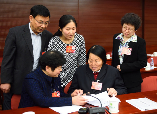 3月11日，申纪兰代表（前右）与其他代表在会后交流。新华社记者 金良快 摄