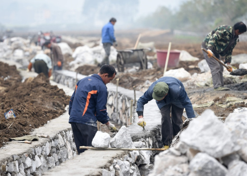 3月12日，忻城县思练镇石龙村村民在田间兴修排涝水渠。近日，广西进入春耕备耕时节，各地共安排农田水利投资161.6亿元，加快冬春水利建设，为春耕生产服务。新华社记者 黄孝邦 摄