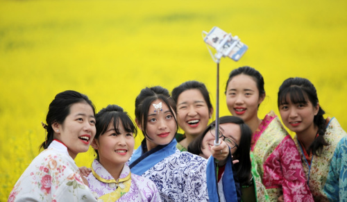 3月12日，游客穿上古装在重庆市永川区青峰镇的油菜花田中留影。新华社发（陈仕川 摄）