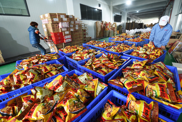 3月11日，在广西螺霸王食品有限公司发货仓库内，工人在运输即将通过快递发货的预包装螺蛳粉。新华社记者 李斌 摄