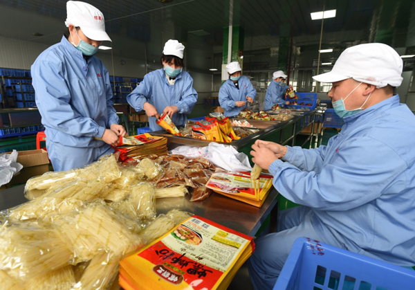 3月11日，在广西螺霸王食品有限公司包装车间内，工人在包装可速食的预包装螺蛳粉。新华社记者 李斌 摄