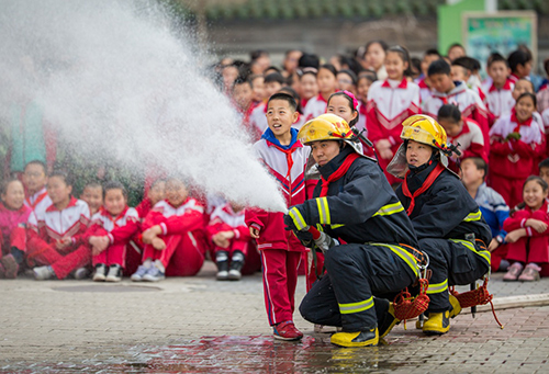 3月28日，内蒙古呼和浩特市玉泉区小召小学学生在消防演练中学习使用水枪。