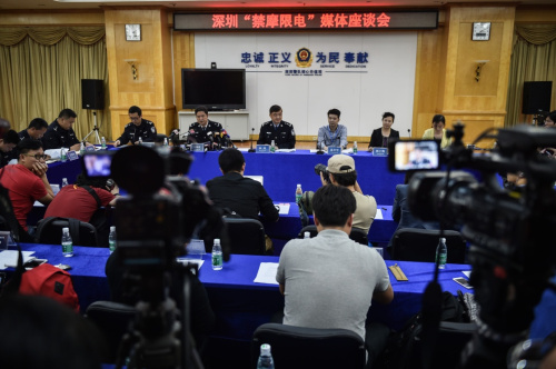 这是4月5日拍摄的深圳“禁摩限电”媒体座谈会现场。当日，深圳市公安交警局召开媒体座谈会，表示将继续与行业协会和企业协商，采取更换交通工具的方法配送快件，并推出后续措施扶持快递业。此前，深圳从3月下旬展开新一轮“禁摩限电”整治行动，涉及深圳快递业普遍使用的电动三轮车，并宣布从4月16日起禁止电动三轮车上路。快递小哥的窘境引起了网购族的同情和大力声援。深圳2011年快递收件量2.4亿件，2015年已达到14亿件，一旦“最后一公里”遇上难题，对市民网购和企业发展也会带来影响。另一方面，由于快递多用超规、改装车，不时还在街头“横行”，早已是城市交通治理的难题。方便快捷与安全之虞的矛盾已成快递之痛，深圳快递小哥未来将用什么方式解决“最后一公里”为人们所关注。新华社记者 毛思倩 摄