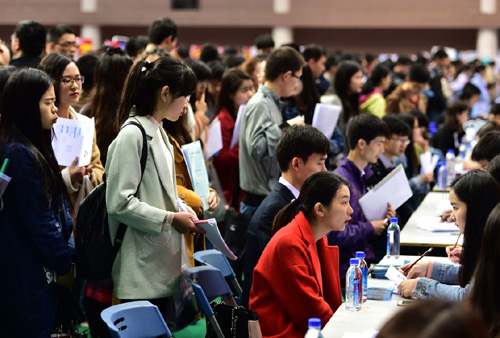 4月6日，求职大学生在招聘会上等待面试。