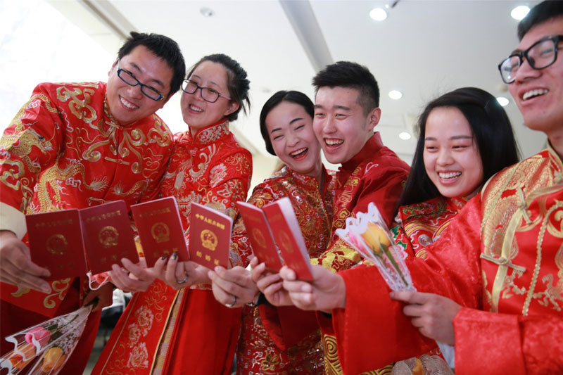 三对新人身着中式服装展示刚领的结婚证