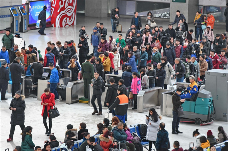 2月21日,旅客排队验票进入长春火车站候车大厅.