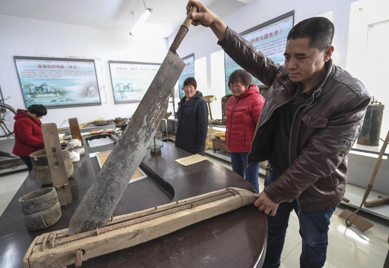 2月28日,村民在河北永清韩村镇九兴区村史馆演示铡刀的使用方法.