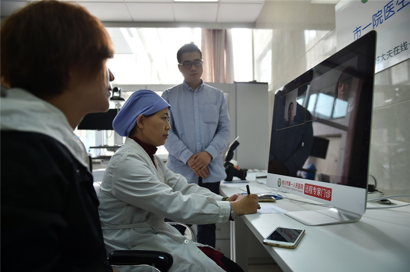 5月5日,在宁夏银川市第一人民医院,医生(中)和患者(左)一起通过视频与