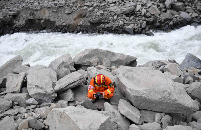 6月26日,救援人员用生命探测仪在四川茂县山体垮塌现场进行搜救.