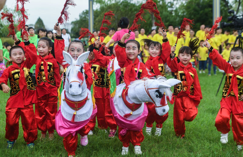日,长兴县开发区中心幼儿园的孩子在三河湾湿地公园内学跳传统马灯舞