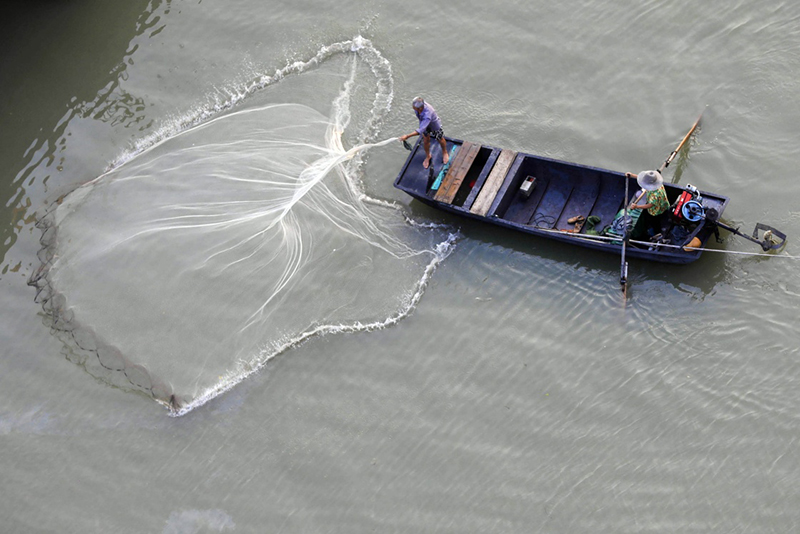 9月13日,在淮河江苏盱眙段,渔民在撒网捕鱼.