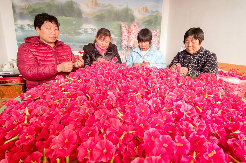 12月29日,河北省武邑县韩庄镇张村留守妇女在制作手工绢花