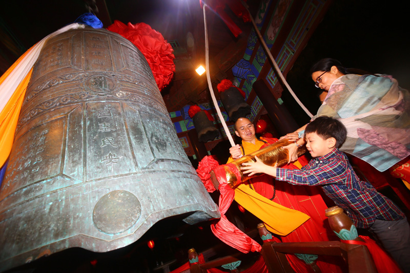 2月15日,海南省三亚市南山寺僧人和游客撞钟祈福.