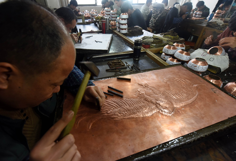 3月21日,技术工人在江西中鼎金属工艺有限公司錾刻铜版画.