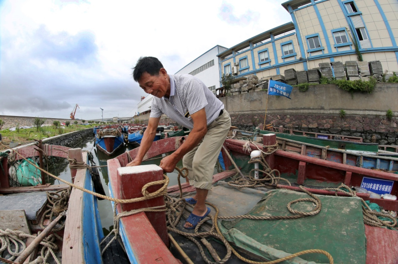 7月21日,浙江省舟山市定海区金塘镇渔民在捆绑渔船.