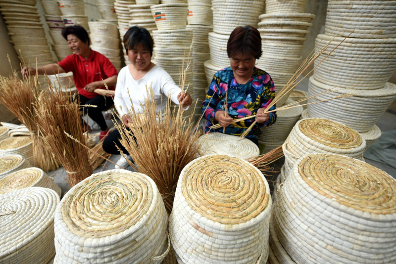 5月28日,山东省临沂市郯城县马头镇草编合作社社员在用秸秆编制工艺品