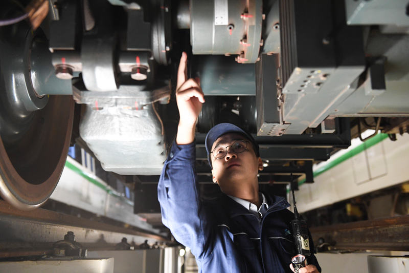 1月1日凌晨,屯里车辆段的地铁检修工在检查车底部件.