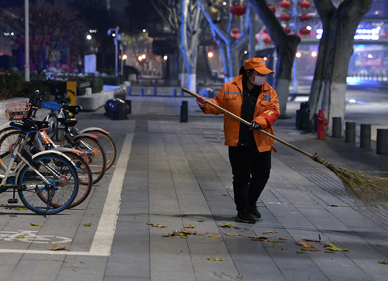 只有亮橙色工装和淡蓝色口罩包裹下的环卫工人时不时出现在马路边