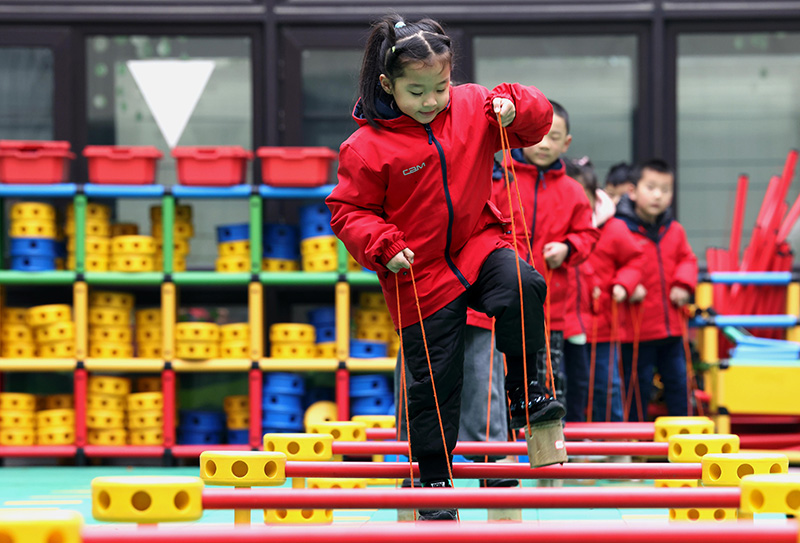 1月27日,孩子们在参加踩高跷传统游戏