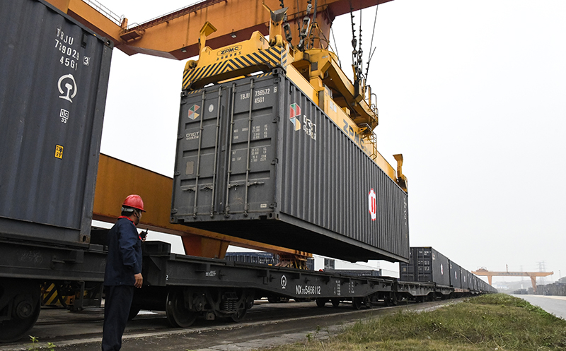 3月12日,在南宁国际铁路港,龙门吊给重型机械中欧班列装运集装箱.
