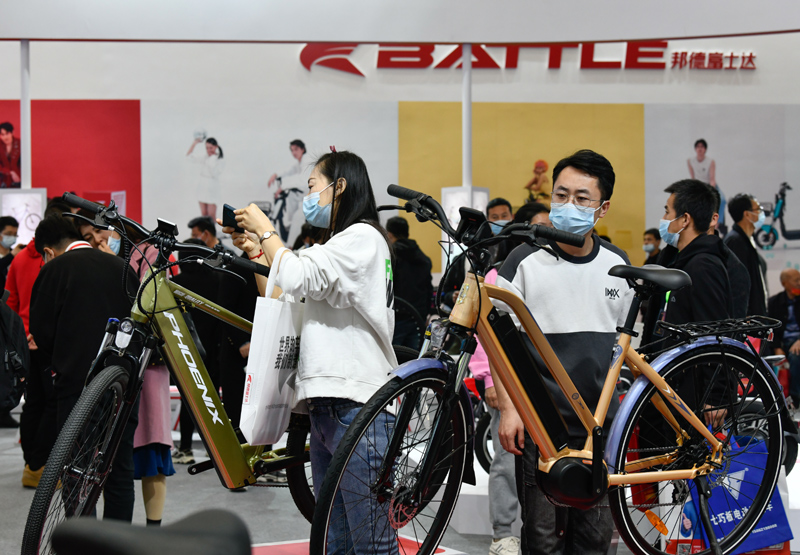 3月26日,观众在展会上参观展出的自行车