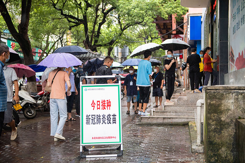 在张家界市永定区永定街道社区卫生服务中心,居民排队接种疫苗