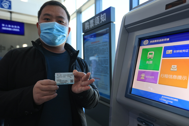 12月5日,在兰新高铁山丹马场站购票的旅客展示车票