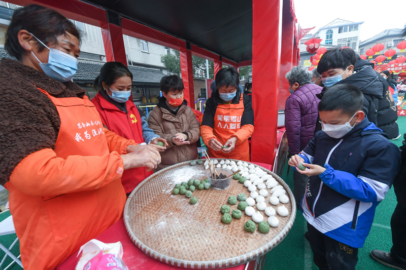 1月25日,在渔山村文化礼堂的民俗活动现场,村民一起制作糯米团子.