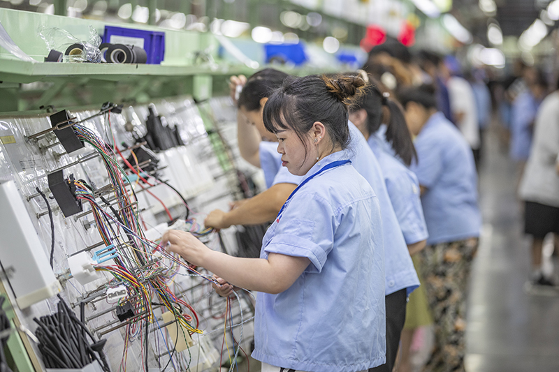 7月19日,在重庆长秦汽车配件有限公司,工作人员在后工序车间进行线束