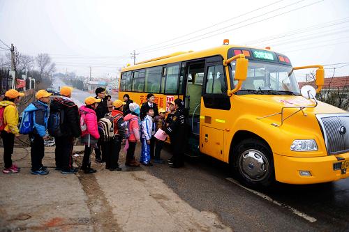2月27日,青岛市开发区董家河社区的小学生在排队乘坐校车。当日,山东省青岛市开发区董家河、施沟、刘家岛、鹿角湾4个农村社区的小学生家长开始与青岛交运集团黄岛汽车总站的校车管理处签订安全承诺书,承诺完成好自己的职责,与校车司乘人员共同维护学生们的乘车安全。董家河、施沟、刘家岛、鹿角湾4个农村社区本学期开通校车,目前青岛开发区共有7200名小学生乘坐由黄岛汽车总站提供的校车。新华社发(俞方平 摄)