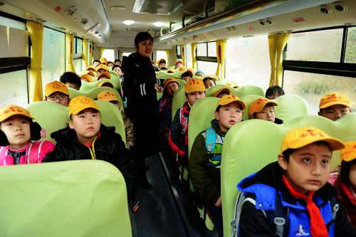 2月27日,山东青岛开发区董家河社区的小学生在乘坐校车。新华社发(俞方平 摄)