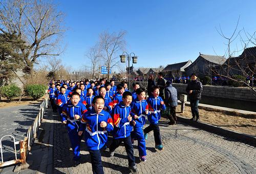 2月27日,北京市第五中学分校的学生们沿着玉河岸边跑步。新华社发(周良 摄)