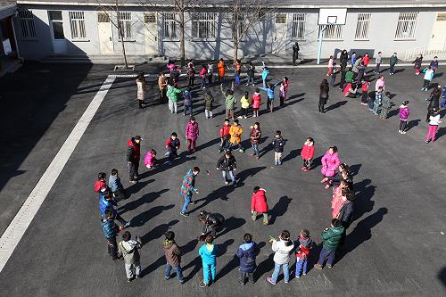 2月27日,北京市东城区西总部小学的学生们在操场上做游戏。新华社发(周良 摄)