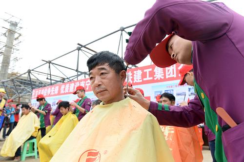 3月1日,在广西南宁市南宁火车东站工地,志愿者在为农民工理发。当日,“情系农民工 关爱在行动”——2014年广西学雷锋集中志愿服务活动(关爱农民工专场)在广西南宁市火车东站施工现场举行。100多名志愿者为现场400多名农民工提供了社会救助、法律、就业、医疗健康等方面的政策咨询及理发、量血压、发放卫生用品等服务。新华社记者 周华 摄