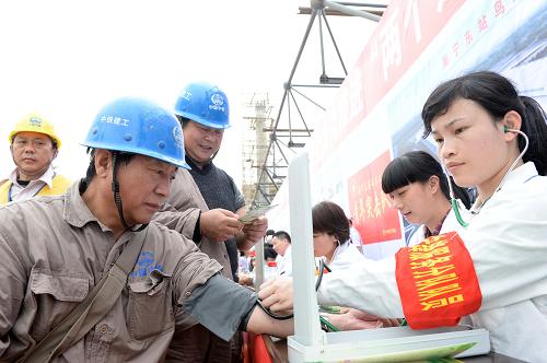 3月1日,在广西南宁市南宁火车东站工地,志愿者在为农民工测量血压。新华社记者 周华 摄