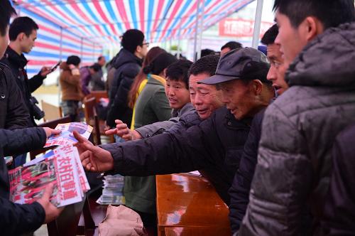 3月1日,在高安县农技农机下乡服务现场,参观者们争相索取赠送的农业知识宣传册。新华社记者 周密 摄