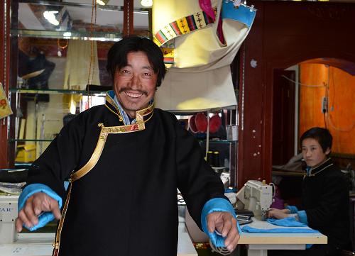 来自墨竹工卡县的农民扎西在新年前特意到拉萨购买藏装(2月25日摄)。普通藏族人习惯,新年之际穿上新衣,以示新的一年有新的气象和新的面貌。藏历木马新年(3月2日)来临之际,拉萨各大藏式服装店生意格外兴隆,除了传统服饰外,时尚藏装走俏市场,备受年轻人青睐。新华社记者 觉果 摄