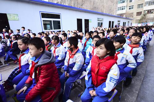 3月1日,西宁市玉井巷小学学生在板房教室外参加新学期开学典礼。当日,青海省各中小学开学。由于教育布局调整,西宁市玉井巷小学将在2014年夏季搬往新校址,西宁市城中区政府为玉井巷小学投资修建板房教室,供师生在过渡时期使用,超过1000名学生将在板房教室内度过搬迁前的最后一个学期。新华社记者 张宏祥 摄