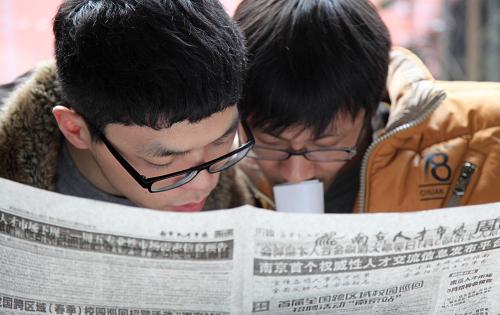 3月2日,两名求职者在招聘活动上查看招聘信息。新华社发(刘建华 摄)