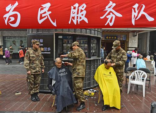 3月5日,“南京路上好八连”官兵在上海南京路为市民免费理发。当日是学雷锋纪念日和中国青年志愿者服务日,上海志愿者在南京路上开展学雷锋志愿服务活动,以实际行动践行和弘扬雷锋精神。新华社发(郭长耀 摄)