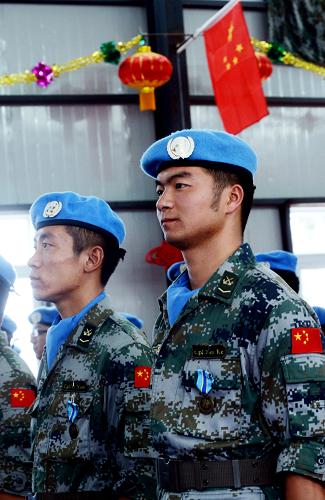 3月5日,维和士兵文珂(右)与战友在授勋大会现场。当日,中国第十六批赴刚果民主共和国(刚果(金))执行维和任务的工兵分队和医疗分队军人在刚果(金)南基伍省省会布卡武接授联合国颁发的维和勋章。新华社记者 王博 摄